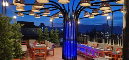 a restaurant with a blue pole with tables and chairs at Park Inn Boutique and Hostel in Kampot
