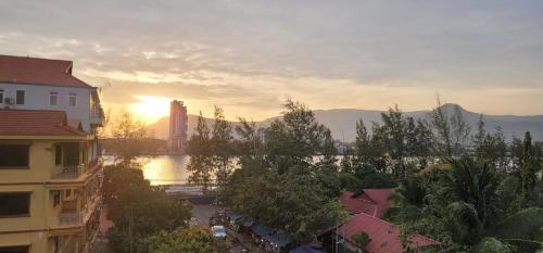 a sunset over a city with buildings and trees at Park Inn Boutique and Hostel in Kampot