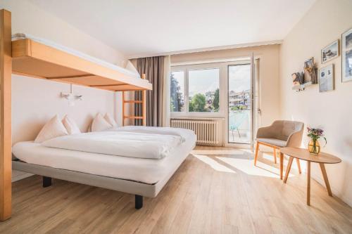 a bedroom with a bunk bed and a chair at Wanderlust Guesthouse in Weggis