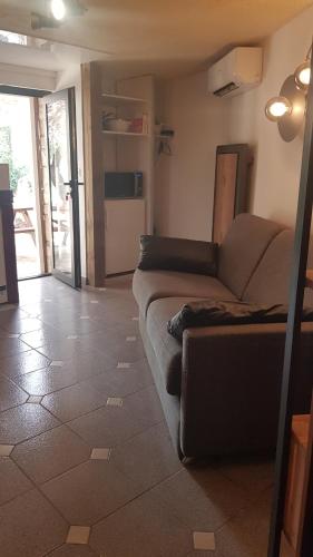 un salon avec un canapé et une cuisine dans l'établissement LE PAILLER 2P et 3 enfants sous le tipi, à Calvi