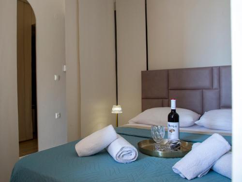 a bed with a bottle of wine and glasses on it at Cozy cave kavala in Kavala