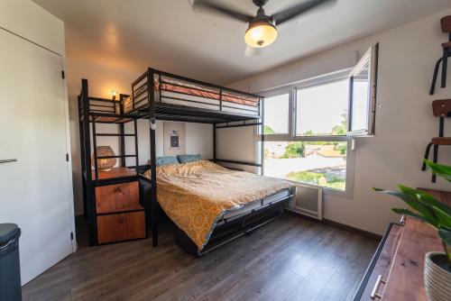 une chambre avec un lit superposé et une grande fenêtre dans l'établissement Sympathique appartement au pied du Futuroscope, à Jaunay-Clan