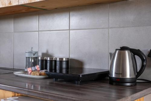 a kitchen counter with a coffee pot and a plate of food at Goshen Guest Farm in Edenburg