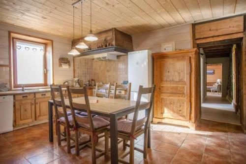 une cuisine et une salle à manger avec une table et des chaises dans l'établissement L'échappée des Rêves, à Verchaix