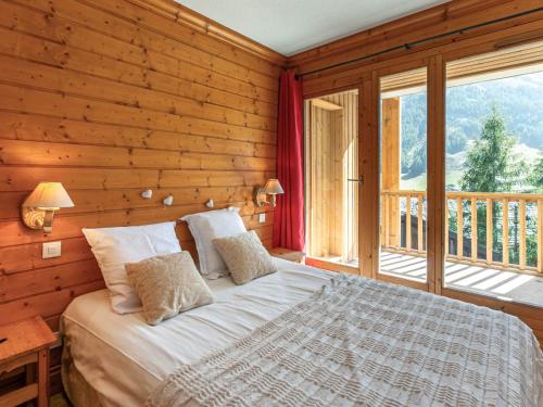 une chambre avec un lit et une grande fenêtre dans l'établissement Charmant 3 pièces avec balcon, vue, et WiFi à Val-d'Isère - FR-1-694-201, à Val dʼIsère
