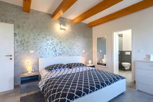 a bedroom with a black and white bed and a bathroom at Villa Civitan with infinity pool in Novigrad in Nova Vas