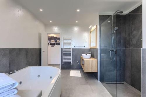 a bathroom with a tub and a shower and a sink at Villa Civitan with infinity pool in Novigrad in Nova Vas