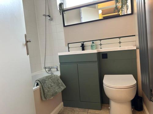 a bathroom with a toilet and a sink and a mirror at Stylish modern flat, Chapel Allerton sleeps 4 in Moortown