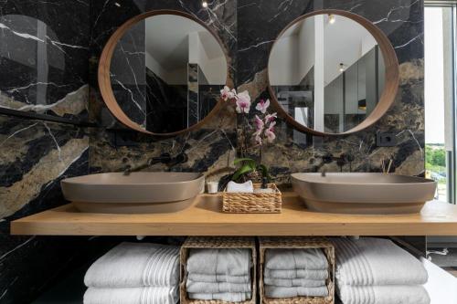 a bathroom with two sinks and two mirrors at Luxury Villa Lipa Tree with pool in Novigrad in Novigrad Istria