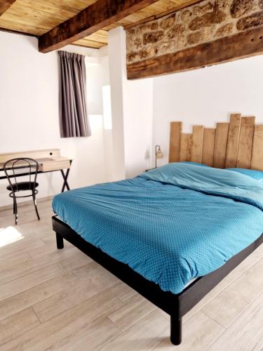 une chambre avec un lit avec une couette bleue dans l'établissement Le Coustouzet - Gîte 10 personnes Bozouls, à Bozouls