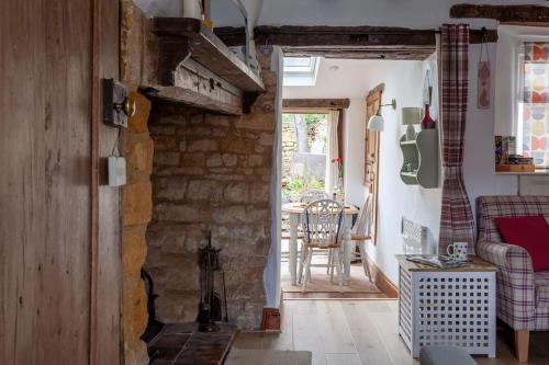 salon z kanapą i kamienną ścianą w obiekcie Cosy Cotswolds cottage with strong WiFi and self check in service 
