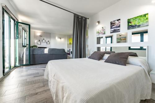 een witte slaapkamer met een groot bed en een bank bij Apartamento Las Vistas in Mijas
