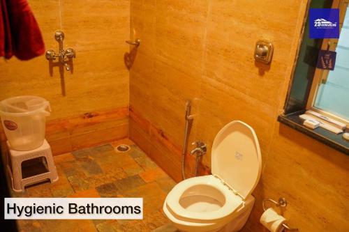 a bathroom with a toilet in a wooden wall at Boutique Room At Bora Bora in Vaishet