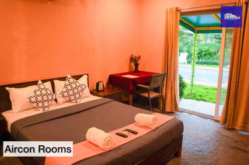 a bedroom with two beds and a table and a window at Boutique Room At Bora Bora in Vaishet