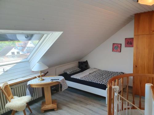 a bedroom with a bed and a table in a attic at Galerie-Apartment in Wendelstein