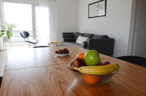 un bol de fruta en una mesa de madera en la sala de estar en Mara, amplio, luminoso y calido en Puerto Madryn