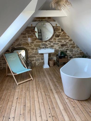 a bathroom with a bath tub and a sink at Les chambres de sainte barbe in Plougasnou