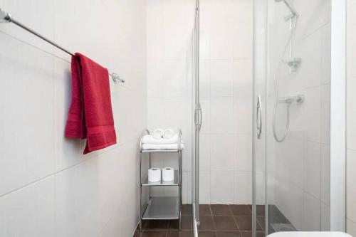 La salle de bains est pourvue d'une douche, de toilettes et de serviettes rouges. dans l'établissement Charming 1 bedroom apartment in the heart of Tallinn, à Tallinn