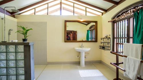 a bathroom with a sink and a mirror at The Chalet in Ahangama