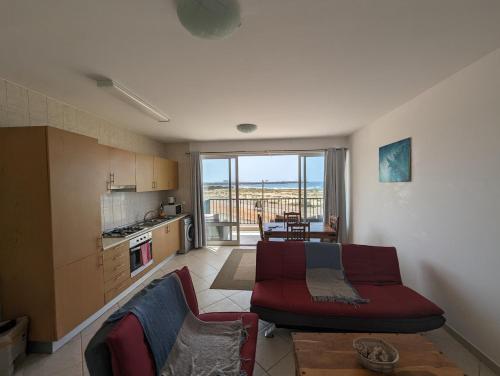 a living room with a couch and a kitchen at Vila Cabral 2 Apartments - AC in Sal Rei