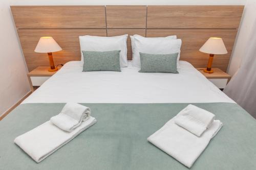 a bedroom with a large white bed with two lamps at Atalaia Sol Aparthotel - tennis & heated pool in winter in Lagos