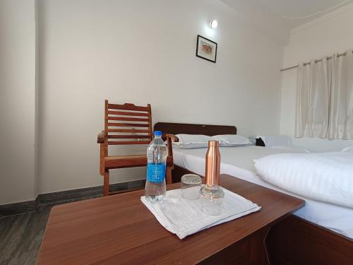 a room with two beds and two bottles of water on a table at CHOUDHARY WHITE HOUSE Udaipur in Udaipur
