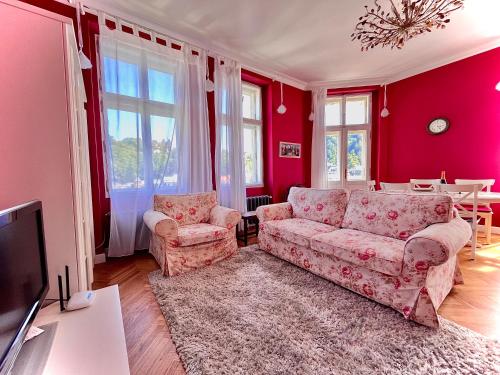 un salon avec deux canapés et une télévision dans l'établissement Bohemian City - Amazing View, Garage, à Karlovy Vary