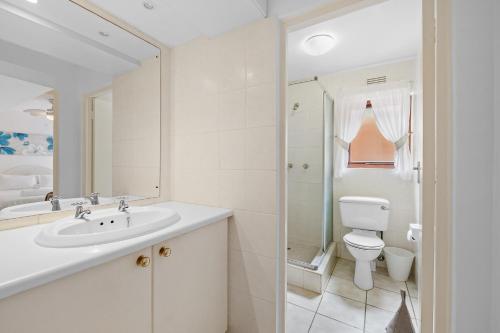 uma casa de banho branca com um lavatório e um WC em San Lameer Villa 3503 - 4 Bedroom Standard- 8 pax - San Lameer Rental Agency em Southbroom