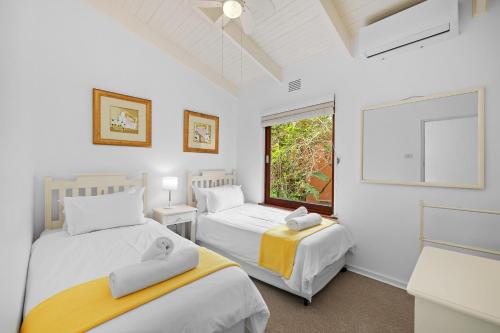 um quarto com 2 camas e uma janela em San Lameer Villa 3503 - 4 Bedroom Standard- 8 pax - San Lameer Rental Agency em Southbroom