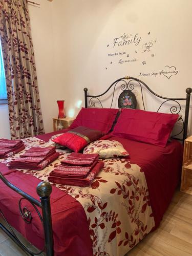 ein Bett mit einer roten Bettdecke und Kissen darauf in der Unterkunft LA CASETTA - chalet in campagna in Legnaro
