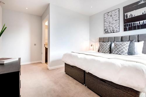 - une chambre avec un grand lit et un bureau dans l'établissement Gravity Camden Lock Apartments, à Londres