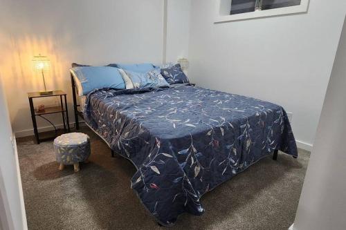 een slaapkamer met een bed met een blauw dekbed bij Glowaide Place in Winnipeg
