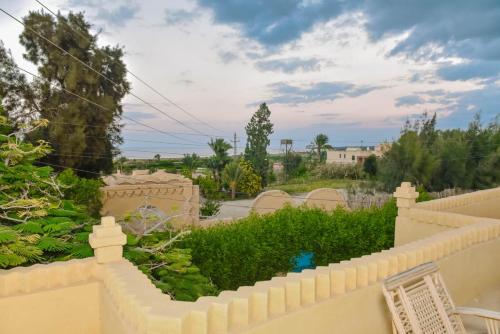 a white fence with a view of a garden at Tunis village in Tunis