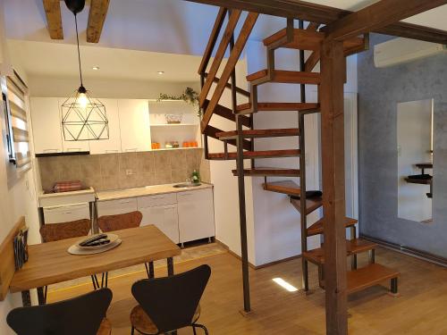 a kitchen and dining room with a wooden spiral staircase at Garden 022 in Vrdnik