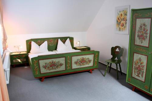 ein Schlafzimmer mit einem grünen Bett mit weißen Kissen in der Unterkunft Schwarzwald-Pension Fechtig in Ühlingen-Birkendorf