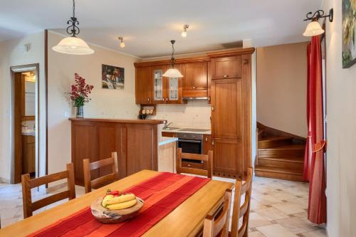 a kitchen with a wooden table with bananas on it at Rustic villa Catarina with pool in Tinjan in Kringa