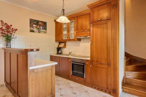 a kitchen with wooden cabinets and a sink at Rustic villa Catarina with pool in Tinjan in Kringa