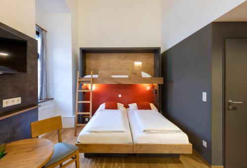 Un pat sau paturi într-o cameră la JUFA Hotel Spital am Pyhrn