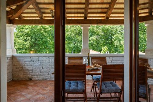 a screened in porch with a table and chairs at Rustic villa Catarina with pool in Tinjan in Kringa