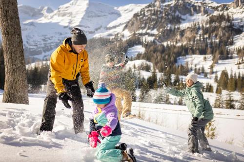 a man and two children playing in the snow at JUFA Hotel Spital am Pyhrn in Spital am Pyhrn