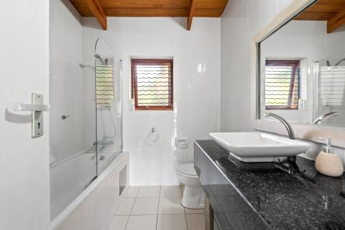 Baño blanco con lavabo y aseo en San Lameer Villa 2704 - 4 Bedroom Classic - 8 pax - San Lameer Rental Agency, en Southbroom