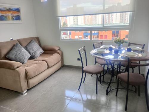 een woonkamer met een bank en een tafel en stoelen bij Apartamento aeropuerto y terminal in Bogota