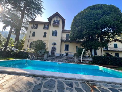 une grande maison avec une piscine en face de celle-ci dans l'établissement VSC Apartment - Appartamento in villa storica vista lago e piscina, à Lesa