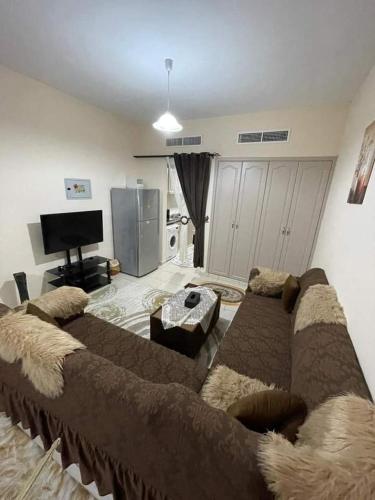 a living room with a large couch and a television at شقق فندقيه in Dubai