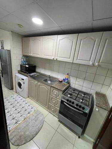 a kitchen with white cabinets and a stove top oven at شقق فندقيه in Dubai