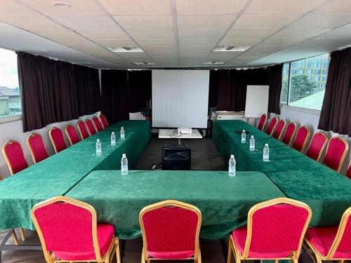 a conference room with a green table and red chairs at Residence ACHENBACH in Abidjan