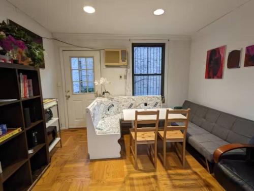 uma sala de estar com um sofá e uma mesa em Cozy room at great Townhouse in Williamsburg em Brooklyn