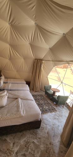 um quarto com 2 camas e uma mesa numa tenda em Family Camp em Wadi Rum