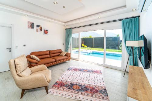 ein Wohnzimmer mit einem Sofa und einem Stuhl in der Unterkunft Villa Ruya by Sakina Escapes in Fethiye