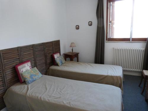 une chambre d'hôtel avec deux lits et une fenêtre dans l'établissement Appartement T2 pied de pistes Génépi, à Uvernet